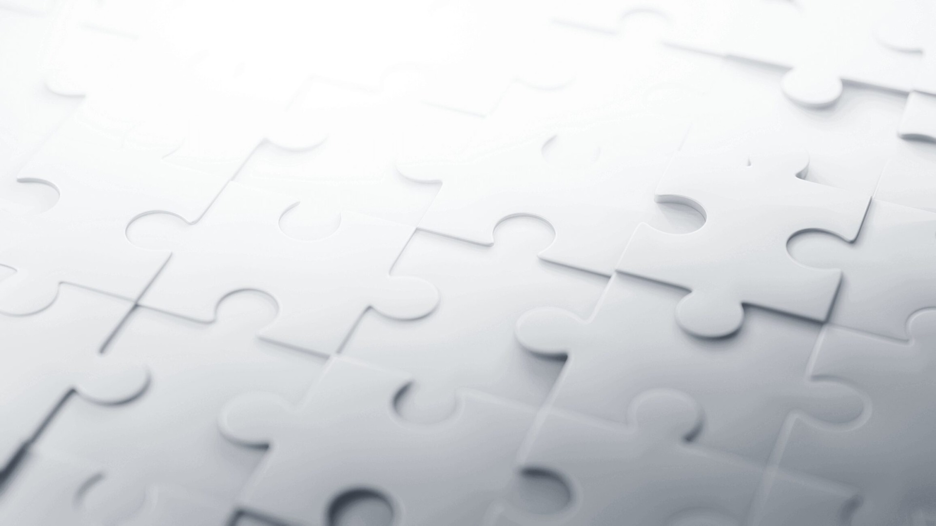 A close-up view of a partially completed jigsaw puzzle in monochromatic blue tones, with a few pieces disconnected, highlighting the concept of putting together an effective compliance management system.